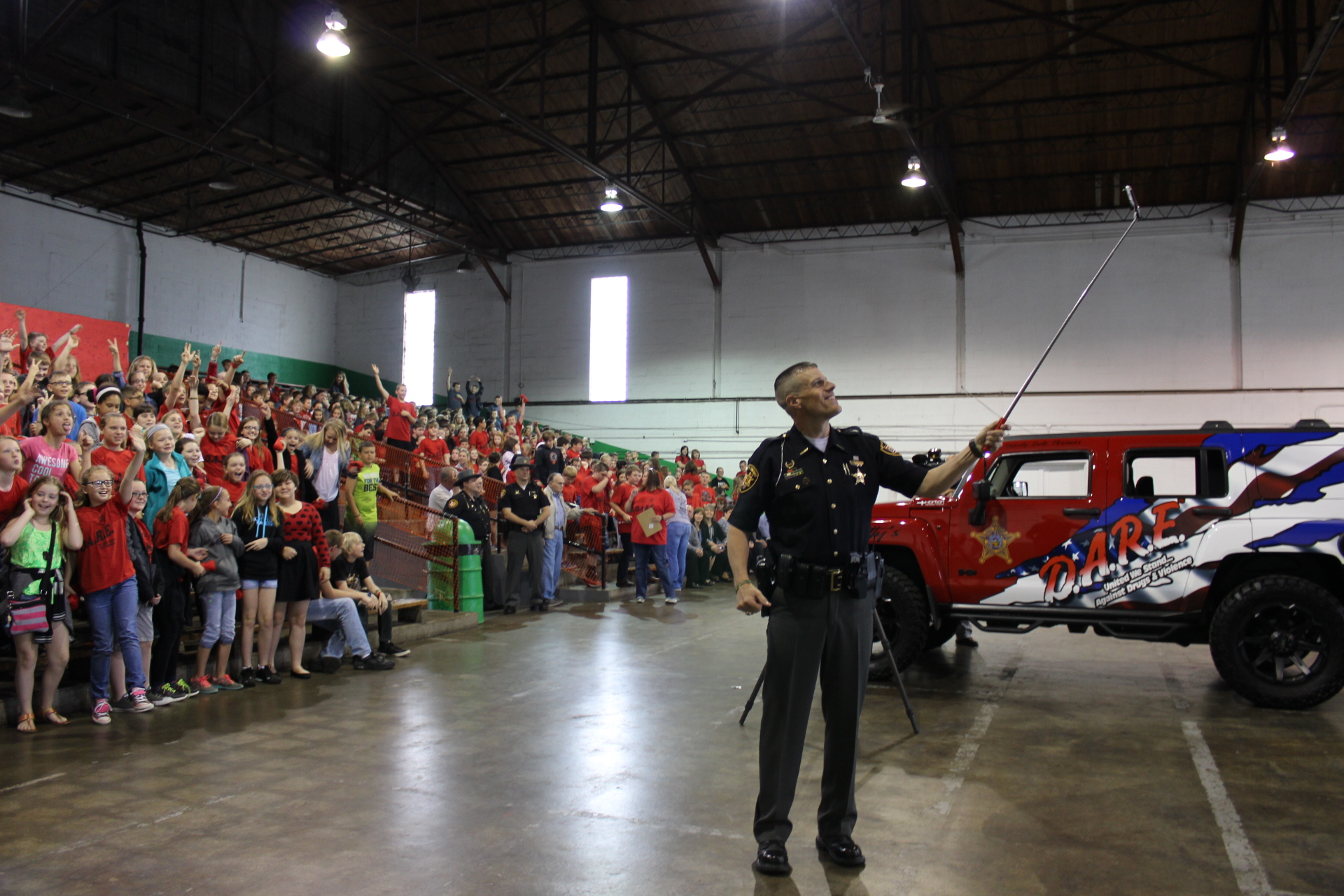 Deputy Thomas takes a selfie with the students beside the new D.A.R.E Hummer 