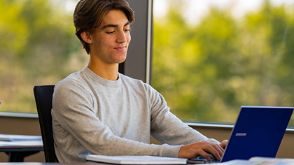 OCU Online student with laptop doing psychology homework
